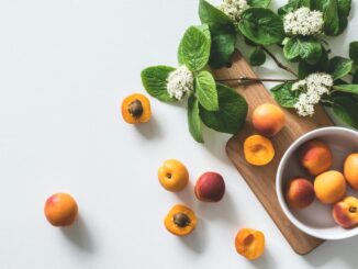 A bright still life of fresh apricots and blossoms on a cutting board, perfect for healthy eating.