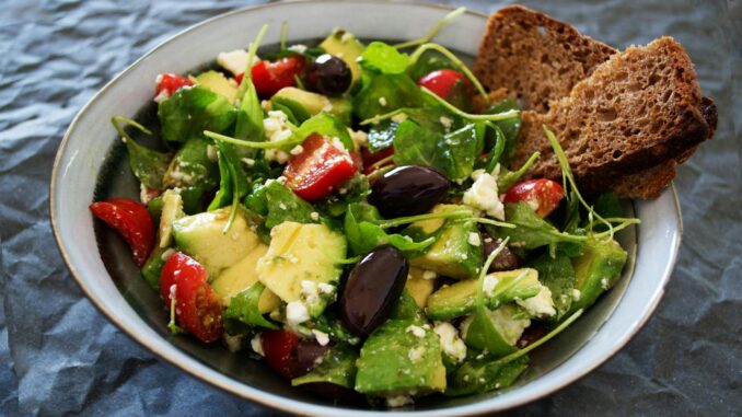 Delicious Greek salad featuring avocado, feta, and olives, ideal for a healthy meal.