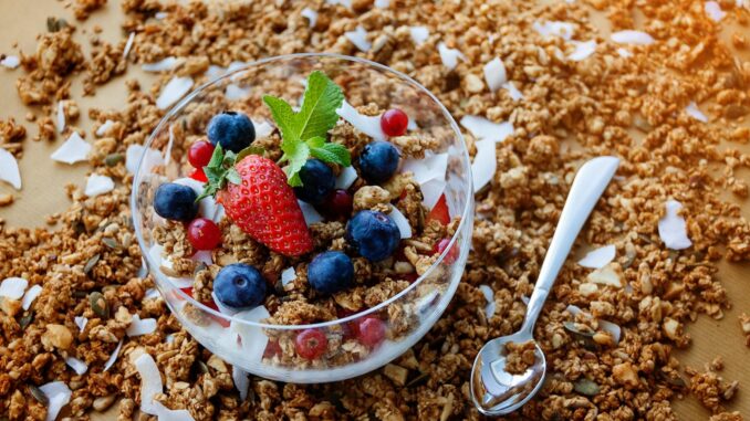 A top view of a healthy granola breakfast with fresh berries and yogurt in București.