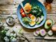 poached egg with vegetables and tomatoes on blue plate